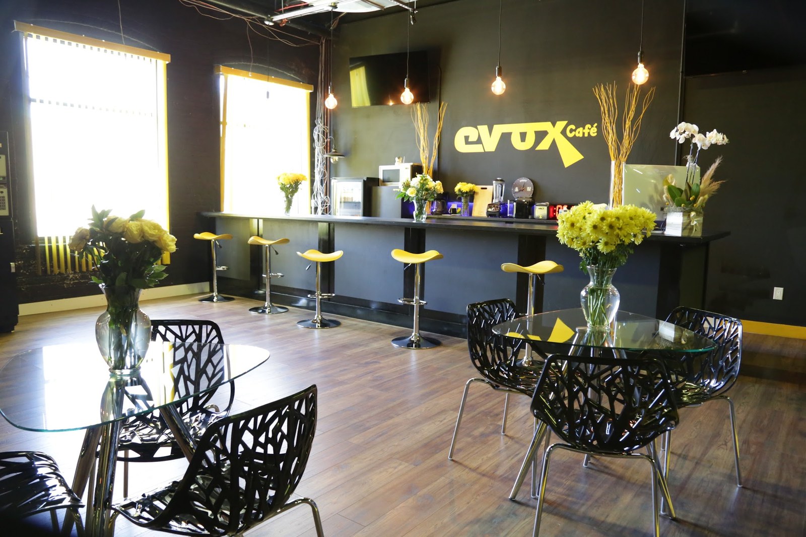 The Evox Café lounge with the yellow evox sign, bar stools and flowers
